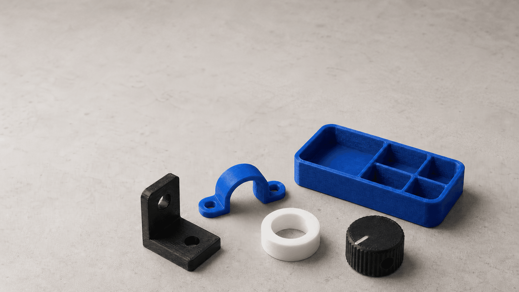 A tidy group of practical black, blue, and white 3D-printed functional parts